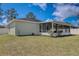 Green backyard featuring a screened-in lanai and well-maintained lawn, perfect for outdoor entertaining at 2604 Hollow Ln, Leesburg, FL 34748