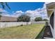 Well-maintained backyard with a white fence, green grass, and landscaping for a private outdoor space at 2604 Hollow Ln, Leesburg, FL 34748