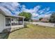 Expansive backyard featuring a screened-in lanai, green lawn, and white vinyl fence for outdoor enjoyment at 2604 Hollow Ln, Leesburg, FL 34748