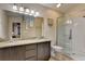 Bathroom featuring dual sinks, granite countertops, and a glass enclosed shower at 2604 Hollow Ln, Leesburg, FL 34748