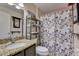 Bathroom featuring a granite countertop sink, decorative shelves, and patterned shower curtain at 2604 Hollow Ln, Leesburg, FL 34748