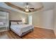 Bedroom with tray ceiling, ceiling fan, and a large window at 2604 Hollow Ln, Leesburg, FL 34748