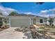 Inviting home with a two-car garage, stone details, and a green lawn at 2604 Hollow Ln, Leesburg, FL 34748