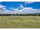 Community football field with well-maintained grass, football goal posts, stadium lights and clear blue skies with fluffy clouds at 2604 Hollow Ln, Leesburg, FL 34748