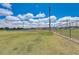 Well-maintained community sports field with bright green grass, tall stadium lights and a clear blue sky with fluffy clouds at 2604 Hollow Ln, Leesburg, FL 34748