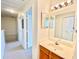 Bathroom view featuring a wood vanity, mirror, and a view of a hallway with white doors at 2605 Gala S Rd # 103, Kissimmee, FL 34746