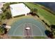 Aerial view of a community basketball court, sand volleyball court, and adjacent pond at 3121 Paradox Cir # 203, Kissimmee, FL 34746