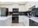 Well-lit kitchen featuring white cabinets, stainless appliances, and sleek gray subway tile backsplash at 3121 Paradox Cir # 203, Kissimmee, FL 34746