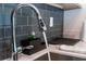 Close up of a stainless steel kitchen sink with a modern faucet and grey subway tile backsplash at 3121 Paradox Cir # 203, Kissimmee, FL 34746