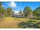 Wide shot of backyard and home with mature trees and a fence, great for pets and privacy at 33 Sunset Dr, Debary, FL 32713