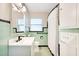 Bathroom with tiled walls, updated vanity, updated fixtures and patterned tile flooring at 33 Sunset Dr, Debary, FL 32713