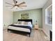 Bedroom with light wood floors, accent wall, ceiling fan, and natural light through dual windows at 33 Sunset Dr, Debary, FL 32713