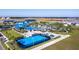 Aerial view of a community basketball court, pool and recreational area with residential buildings in the distance at 3373 Lilac Way, Davenport, FL 33897