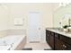 Bright bathroom featuring soaking tub and vanity with granite countertops at 3373 Lilac Way, Davenport, FL 33897