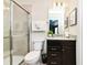 Well lit bathroom featuring a glass shower, granite countertops, a dark brown vanity with chrome hardware and a plush white towel at 3373 Lilac Way, Davenport, FL 33897