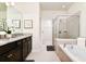 Bright bathroom featuring dual vanities, walk-in shower, and soaking tub at 3373 Lilac Way, Davenport, FL 33897