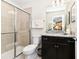 Bright bathroom featuring a glass shower, vanity with granite countertops, dark brown cabinets, and neutral wall colors at 3373 Lilac Way, Davenport, FL 33897