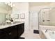 Bright bathroom featuring dual vanities, walk-in shower, and soaking tub at 3373 Lilac Way, Davenport, FL 33897