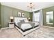 Bedroom featuring sage green walls, a striking light fixture, and large windows that let in plenty of natural light at 3373 Lilac Way, Davenport, FL 33897