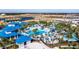 Aerial view of a resort-style community pool with lazy river, waterslides, beach volleyball, and extensive lounging areas at 3373 Lilac Way, Davenport, FL 33897