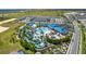 Aerial view of a resort-style community pool with lazy river, waterslides, beach volleyball, and extensive lounging areas at 3373 Lilac Way, Davenport, FL 33897