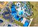 Aerial view of a resort-style community pool with lazy river, waterslides, beach volleyball, and extensive lounging areas at 3373 Lilac Way, Davenport, FL 33897