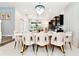 Stylish dining room with modern chairs, chandelier lighting, and access to the kitchen, great for hosting at 3373 Lilac Way, Davenport, FL 33897