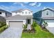 Exterior shot of a two story house with a paved driveway, manicured lawn, and a two-car garage at 3373 Lilac Way, Davenport, FL 33897