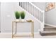 Stylish entry table with plants and decor, positioned near the staircase in a bright hallway setting at 3373 Lilac Way, Davenport, FL 33897