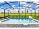 Inviting screened-in pool with lounge chair and a view of the expansive green lawn at 3373 Lilac Way, Davenport, FL 33897