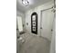 Bright entryway with light wood-look tile, white doors, and a modern archway featuring framed photos at 36104 Emeralda Ave, Leesburg, FL 34788