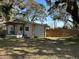 Quaint home showing horizontal siding with a cozy front porch swing and privacy fence at 36104 Emeralda Ave, Leesburg, FL 34788