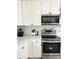 Stainless steel oven and range top with white cabinets and marble countertops at 36104 Emeralda Ave, Leesburg, FL 34788