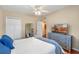 Bright bedroom with a ceiling fan, mirrored closet doors, and a dresser with a TV at 382 Frances Ave, Casselberry, FL 32707