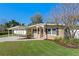 Charming single-story home with manicured lawn, carport, and a welcoming red front door at 382 Frances Ave, Casselberry, FL 32707