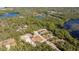 Aerial view of homes near a serene lake, surrounded by lush green trees at 41915 Aspen St, Eustis, FL 32736