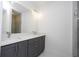 Bathroom featuring a large mirror, dual sinks, gray cabinets, and a glass shower door at 41915 Aspen St, Eustis, FL 32736