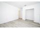 A clean bedroom featuring gray wood-look floors, white trim, and closet at 41915 Aspen St, Eustis, FL 32736