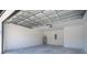 Spacious garage featuring a concrete floor, white block walls, overhead door, and water heater at 41915 Aspen St, Eustis, FL 32736