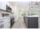 Contemporary kitchen with stainless steel appliances, island with pendant lights, and open to the living room at 41915 Aspen St, Eustis, FL 32736