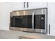 Close-up of the stainless steel microwave over a white backsplash and cabinet with black hardware at 41915 Aspen St, Eustis, FL 32736