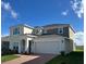 Two-story home featuring a two-car garage, neutral colors, and a well-manicured lawn at 4229 Deleon St, Haines City, FL 33844