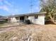 A single story home with a backyard featuring a covered patio with white railings and a partially fenced yard at 4270 Solomon Dr, Orlando, FL 32811