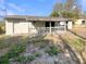 A single story home with a backyard featuring a covered patio with white railings and a private entrance at 4270 Solomon Dr, Orlando, FL 32811