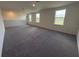 Large bonus room featuring wall-to-wall carpet and multiple windows at 4972 Lyric Dr, Mascotte, FL 34753