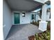 View of the front porch with a green door, dark walkway, and green shutters at 4972 Lyric Dr, Mascotte, FL 34753