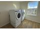 Bright laundry room featuring new Samsung washer and dryer next to a window at 4972 Lyric Dr, Mascotte, FL 34753