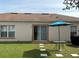 Charming backyard with patio doors, patio set with umbrella, and stepping stones at 504 Delido Way, Kissimmee, FL 34758