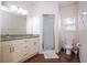 Bathroom featuring double vanity sinks, a glass-enclosed shower, and neutral wall colors at 5356 Diplomat Ct # 105, Kissimmee, FL 34746