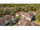 Aerial view of townhomes with neat landscaping, roofs, and mature trees at 5356 Diplomat Ct # 105, Kissimmee, FL 34746